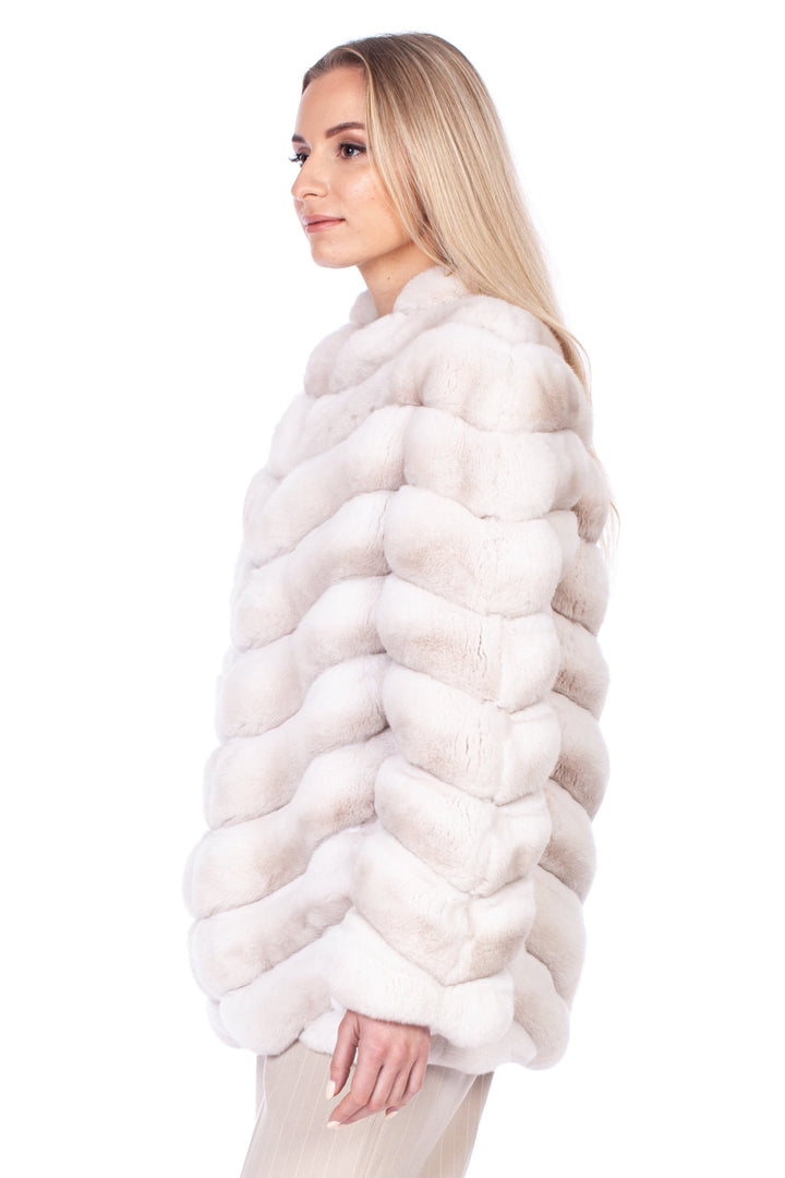 A person with long blonde hair, wearing the luxurious Cream Chinchilla Fur Coat by FurbySD and light beige pants, stands confidently against a white background, displaying a side profile while adorned in high-heeled sandals.