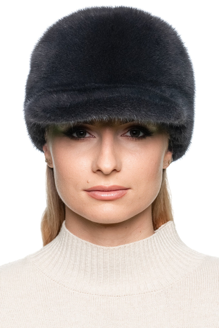 Dark grey mink fur baseball cap, handmade winter hat with brim shown from the front on model, unisex adjustable luxury fur cap for cold weather fashion.