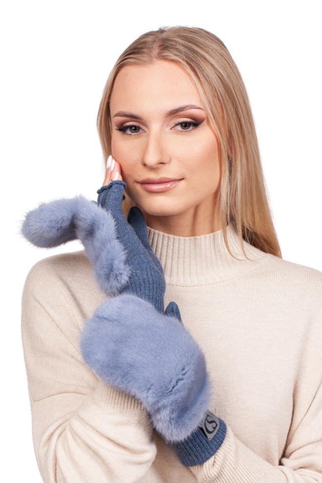 A person wearing a beige sweater is showcasing the luxurious winter accessories from FurbySD: the Denim Blue Mink Fur Flip Top Mittens. These elegant mittens, adorned with fluffy mink fur details, partially cover their fingers for a stylish look against the plain white background.