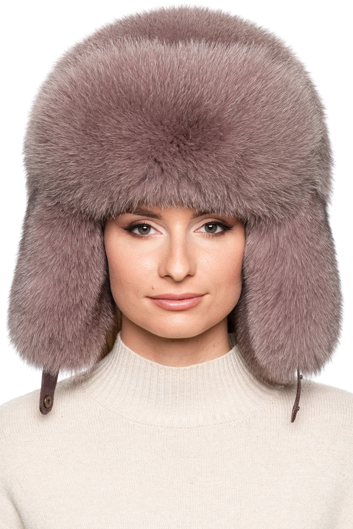 Luxury dusty pink fox fur trapper hat for women, oversized Russian ushanka style with plush earflaps and voluminous crown, warm winter fur fashion accessory.