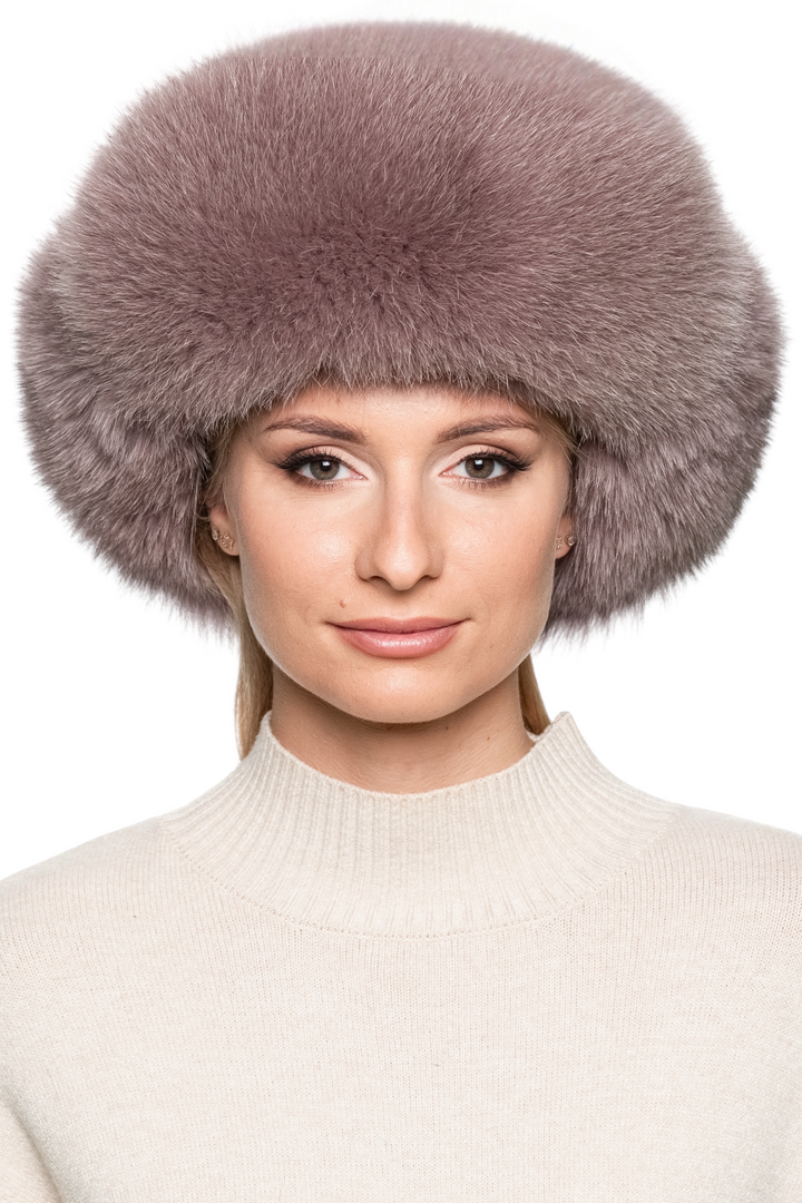 Front view of women’s dusty pink fox fur trapper hat, thick plush fur with earflaps down, oversized ushanka style winter hat for après-ski elegance.