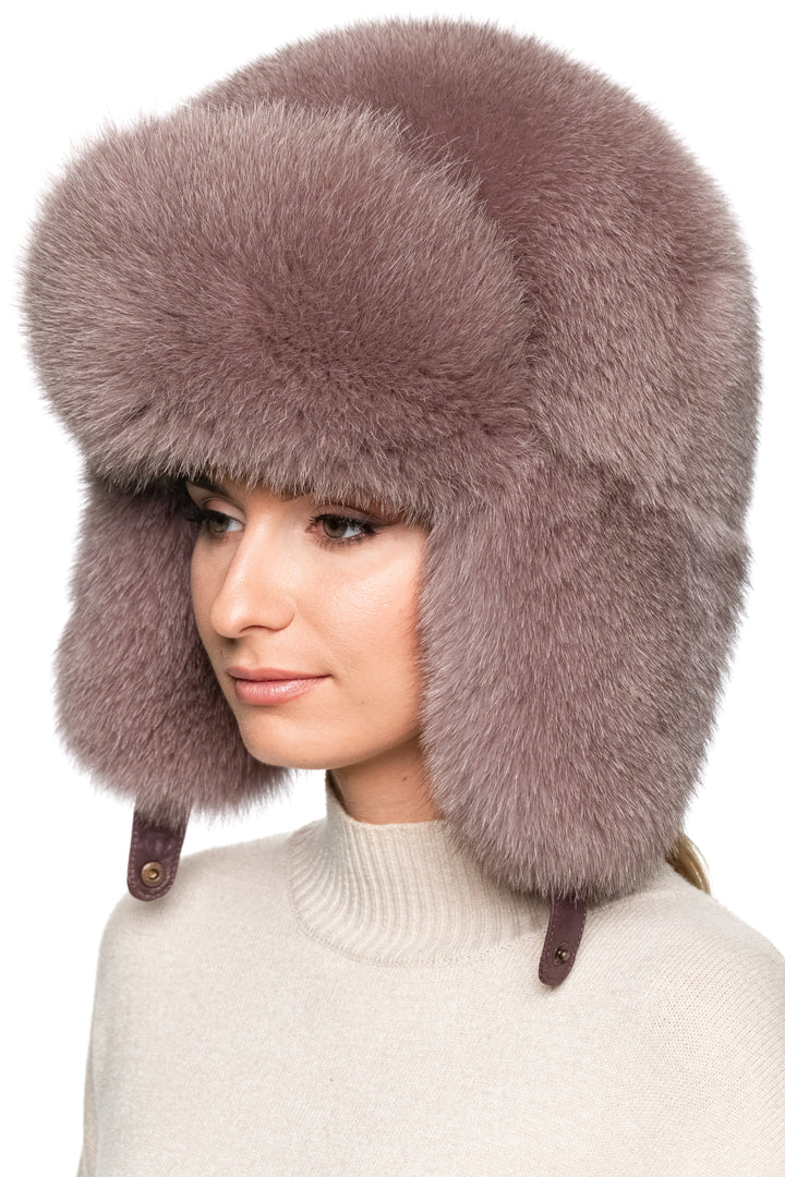 Luxury dusty pink fox fur trapper hat, right side profile view with voluminous earflaps, oversized Russian ushanka style hat for women’s winter fashion.
