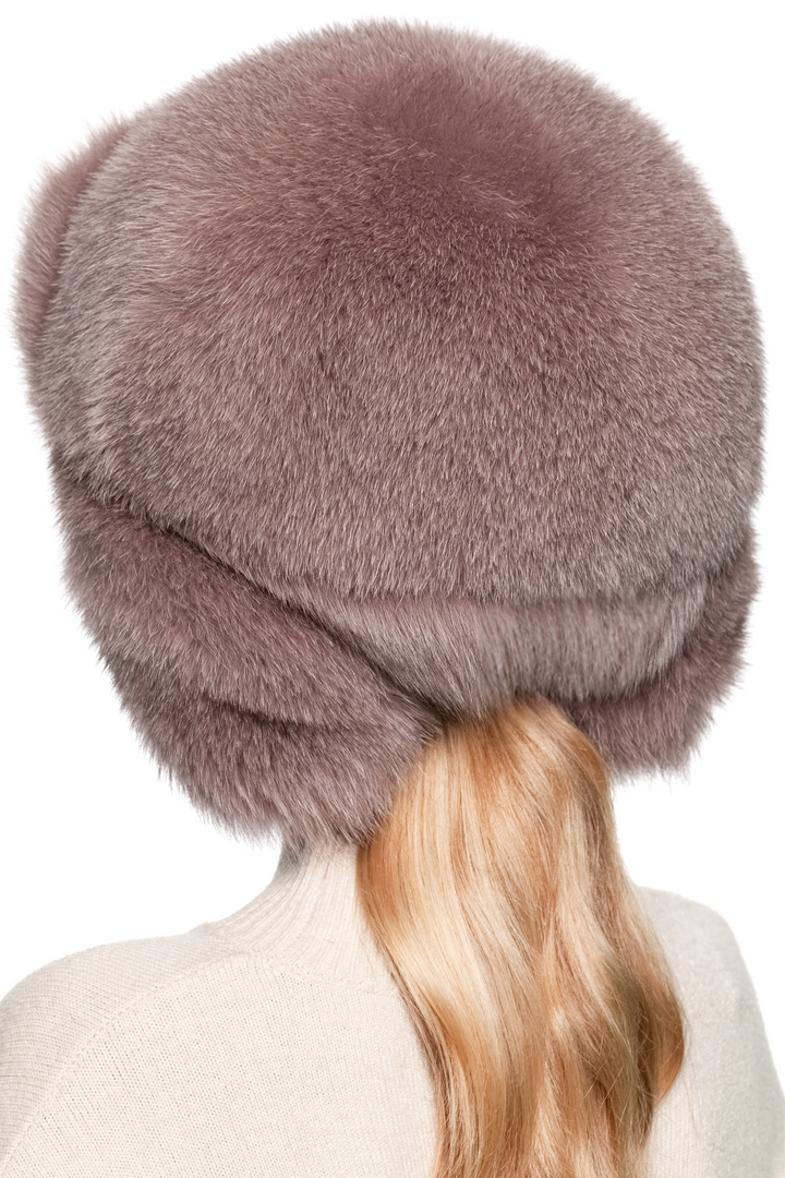 Profile view of women’s dusty pink fox fur trapper hat, thick plush fur with earflaps down, oversized ushanka style winter hat for après-ski elegance