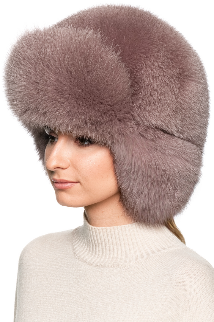 “Front view of oversized dusty pink fox fur trapper hat with thick fluffy crown and earflaps, handmade women’s ushanka hat, luxury après-ski winter accessory.