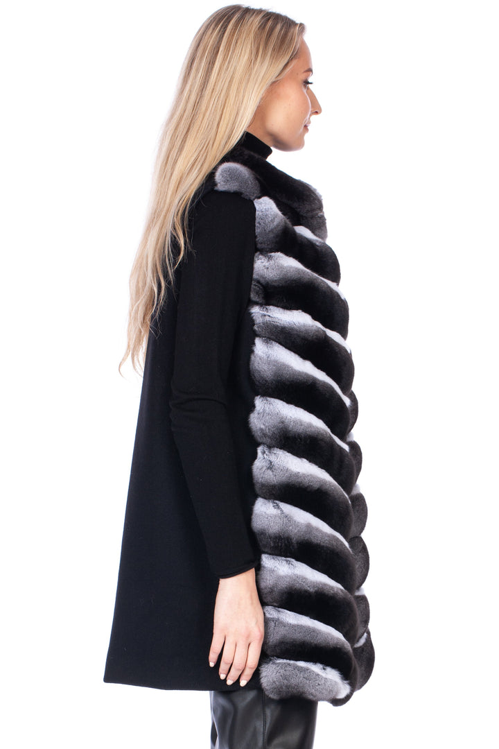 Person wearing a black cashmere sweater with a chinchilla fur vest on a white background.