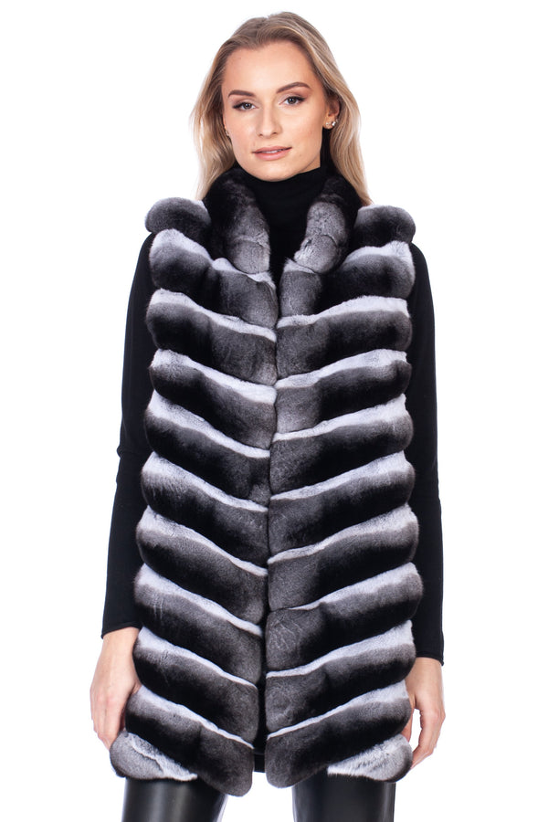 Woman wearing a black and gray natural chinchilla fur vest on a white background