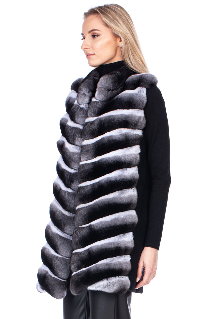 Woman wearing a black and gray genuine chinchilla fur vest on a white background