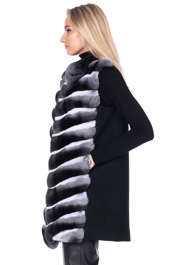 Woman wearing a long chinchilla fur vest with cashmere wool on the back with a white background.