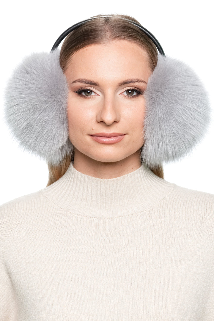 Woman wearing grey fox fur earmuffs with black leather band – handmade fluffy real fur ear warmers for winter, luxury Christmas gift idea for her.