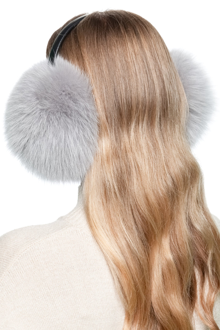 Angled close-up of grey fox fur earmuffs, handmade fluffy real fur winter ear warmers with sleek leather band, cozy and stylish gift for women.
