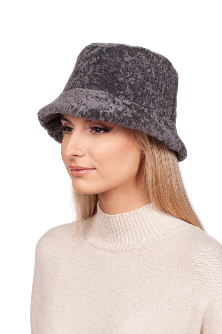 A person with long hair, wearing a Grey Lambskin Fisherman’s Hat by FurbySD and a cream sweater, looks to the side with a neutral expression against a plain white background.