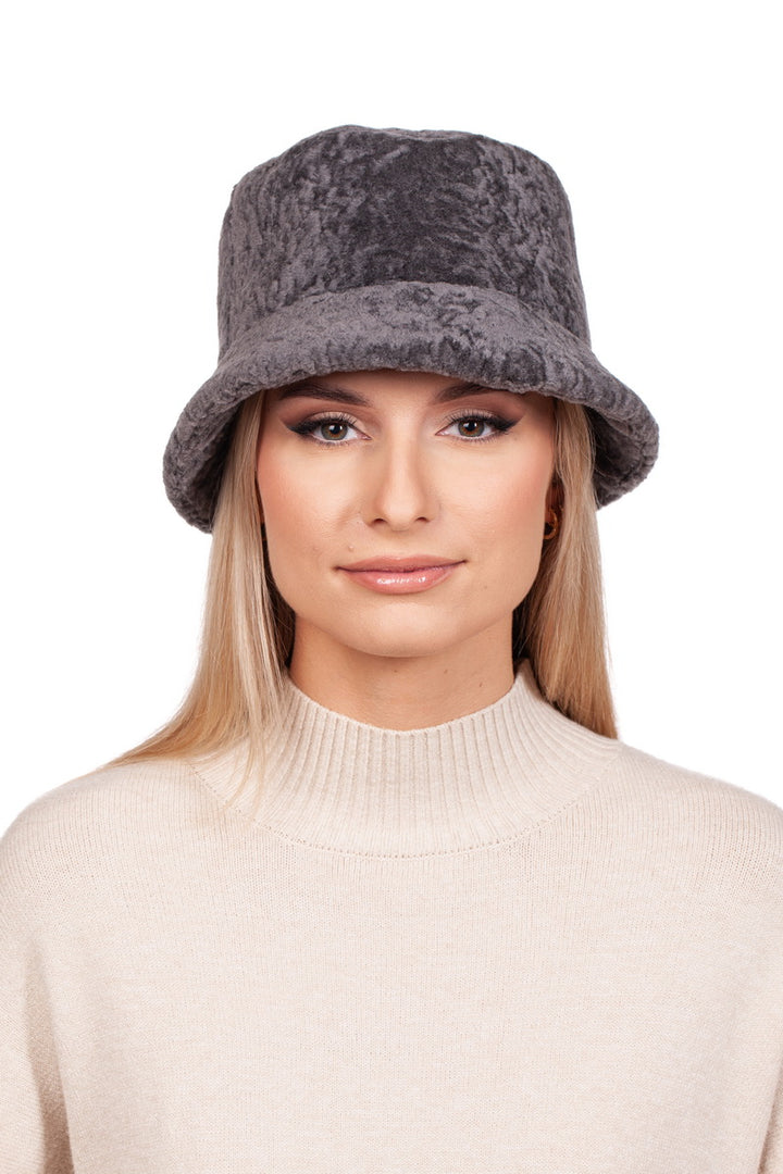 A person with long blond hair is wearing a Grey Lambskin Fisherman’s Hat from FurbySD and a beige sweater, posing against a white background.