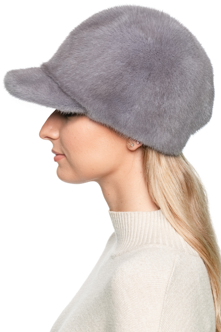 Left profile of grey mink fur baseball cap on model — handmade sporty mink fur hat for winter warmth.