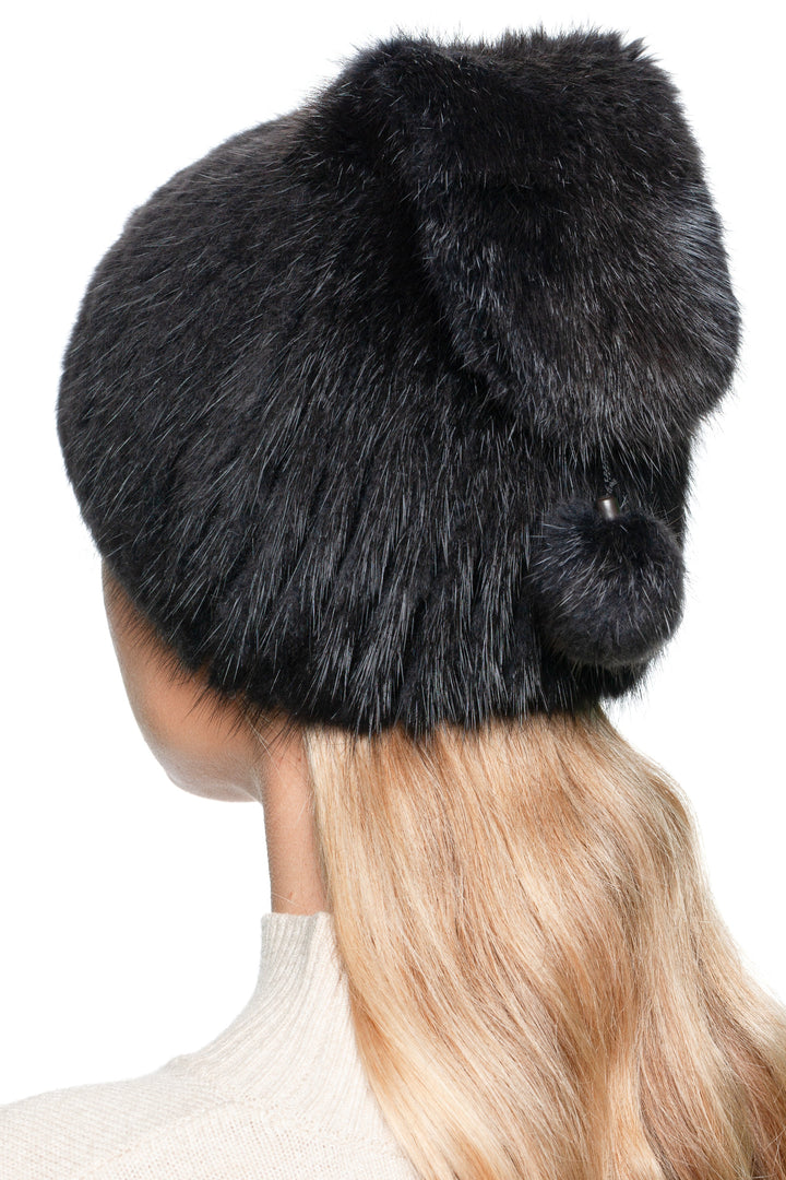 Back angle of a grey muskrat fur beanie hat with pom pom, real fur knit winter hat.