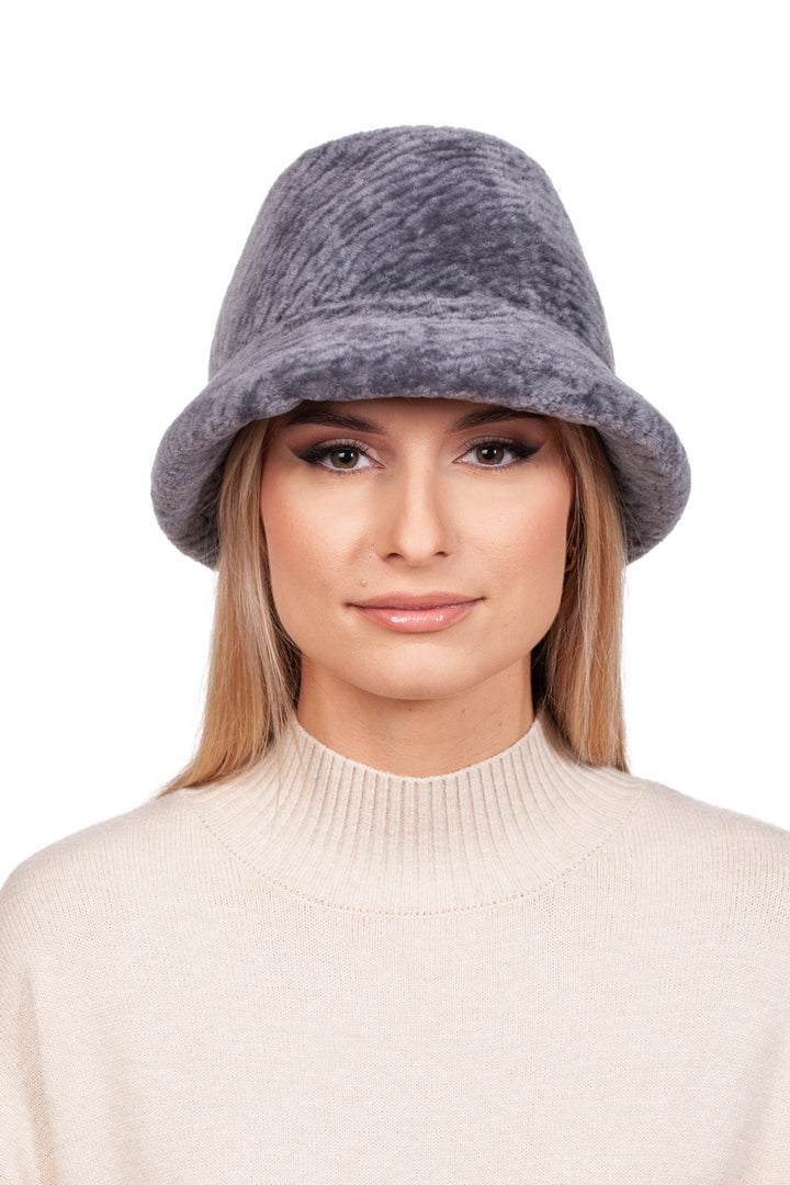 A person with long blonde hair is wearing the Grey Sheepskin Bucket Hat by FurbySD, featuring a flexible brim, paired with a cream-colored sweater, and is looking directly at the camera against a plain white background.