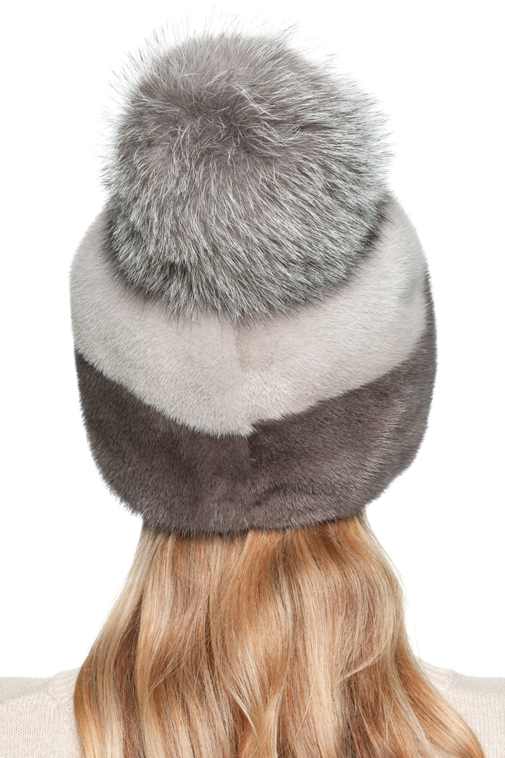Rear view of grey and brown mink fur beanie hat with fluffy silver fox pom pom, showcasing smooth fur texture and luxury craftsmanship.
