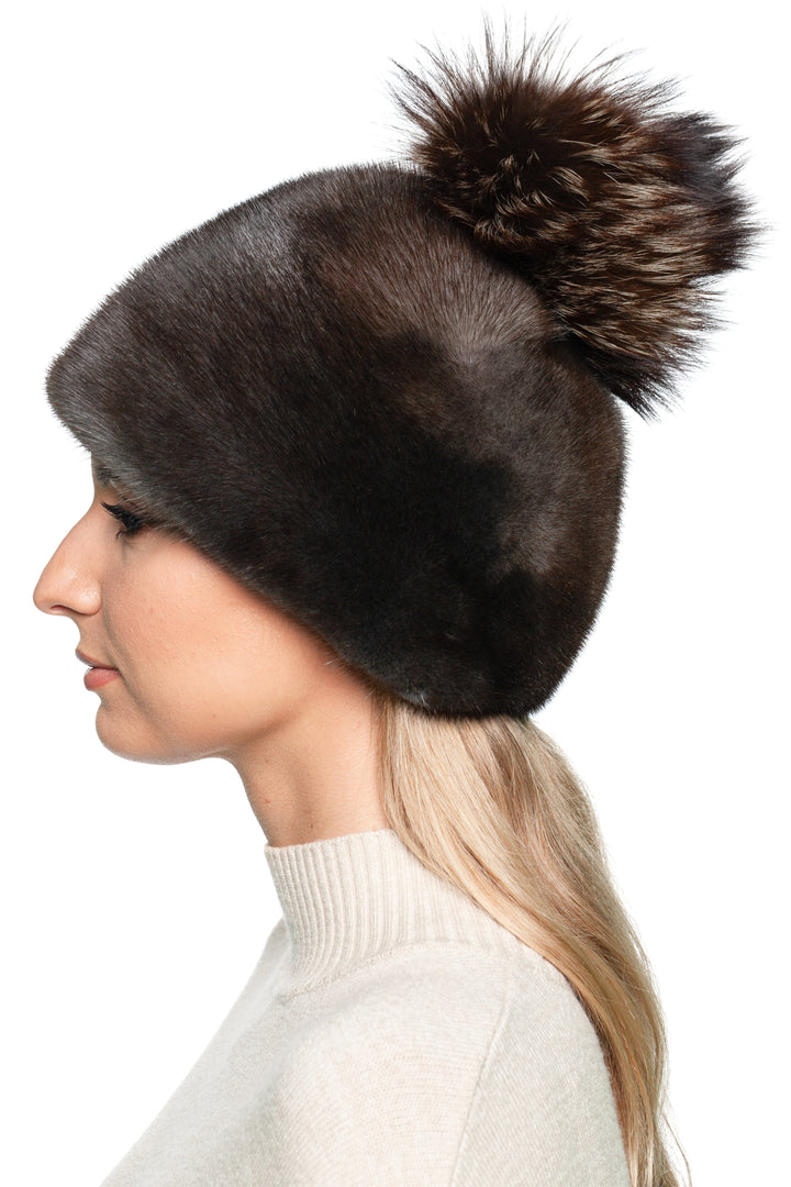 Elegant greyish brown mink fur hat with fox fur bobble, stylish handmade women’s winter headwear for cold weather.