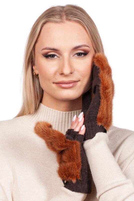 A woman with long blonde hair smiles as she holds a pair of FurbySD’s Rust Brown Mink Fur Mittens to her face while wearing a beige sweater, all set against a plain white background.