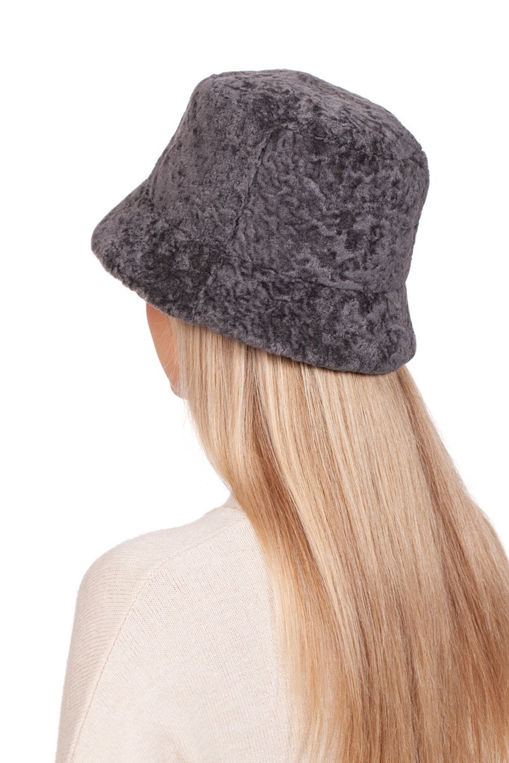 A person with long blonde hair is wearing the FurbySD Grey Lambskin Fisherman’s Hat and a cream sweater, facing away from the camera against a white background.