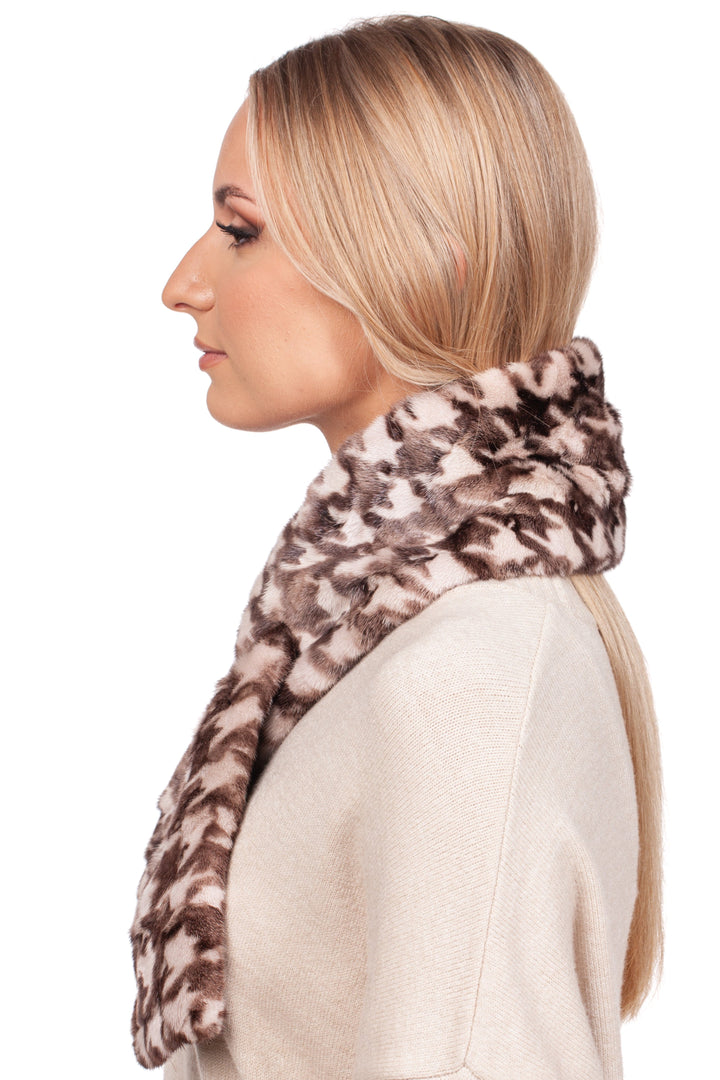 A person with long blonde hair is in side profile, wearing a light beige sweater and the FurbySD Houndstooth Mink Fur Scarf With Keyhole in brown and beige, set against a plain white background.