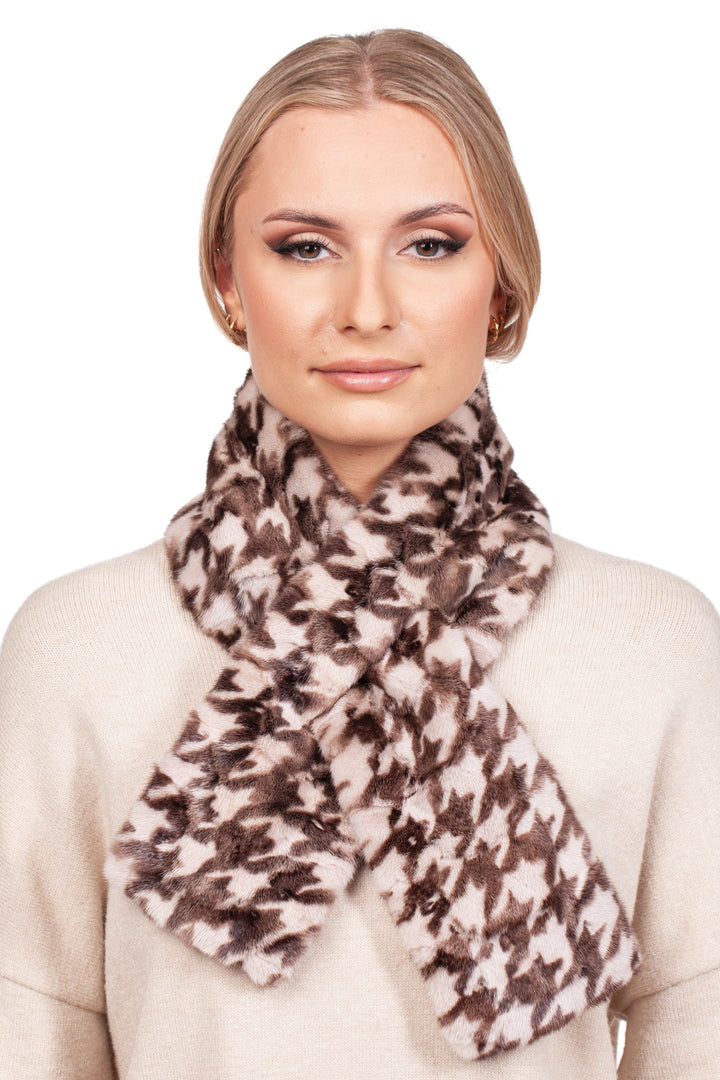 A person wearing a cream sweater and the luxurious Houndstooth Mink Fur Scarf With Keyhole from FurbySD stands against a white background. Their hair is pulled back, and they have natural makeup with a neutral expression.