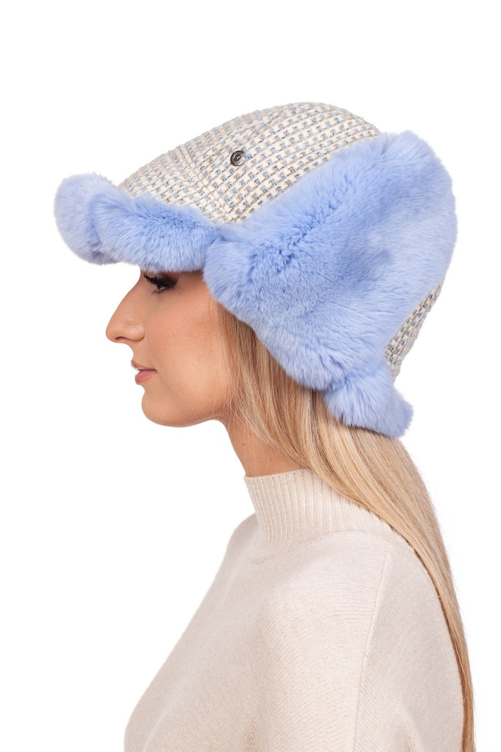 A person with long hair models a light-colored sweater paired with the Blue Chinchilla Fur Ushanka Hat from FurbySD. The hat features fluffy blue chinchilla fur ear flaps and a textured pattern on the top, set against a white background.