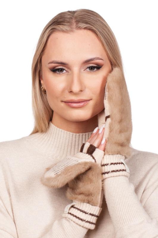 A person with long blonde hair wearing a cream-colored sweater poses with their hands touching their face, showcasing the FurbySD Beige Mink Fur Hat And Flip Top Mittens Set. They exude style and elegance with fluffy, light brown mittens featuring dark stripe details—a true embodiment of luxury winter accessories.