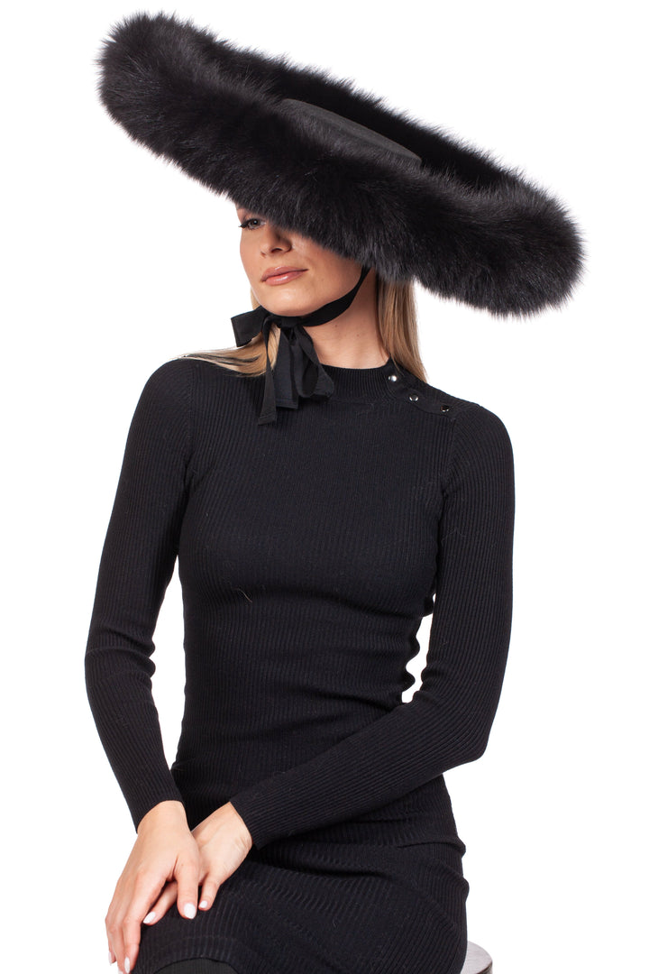 A woman in a black dress is wearing the FurbySD Black Fox Fur Trimmed Wide Brim Fedora Hat, featuring a ribbon tied under her chin as she poses against a plain white background.