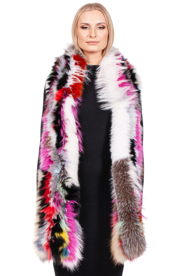 A woman with short blonde hair is wearing the FurbySD Long Knitted Fox Fur Scarf, a luxurious accessory with multicolor shades of pink, purple, red, black, yellow, and white beautifully accentuating her black outfit. Smiling and facing forward, she exudes elegance with her stunning scarf.