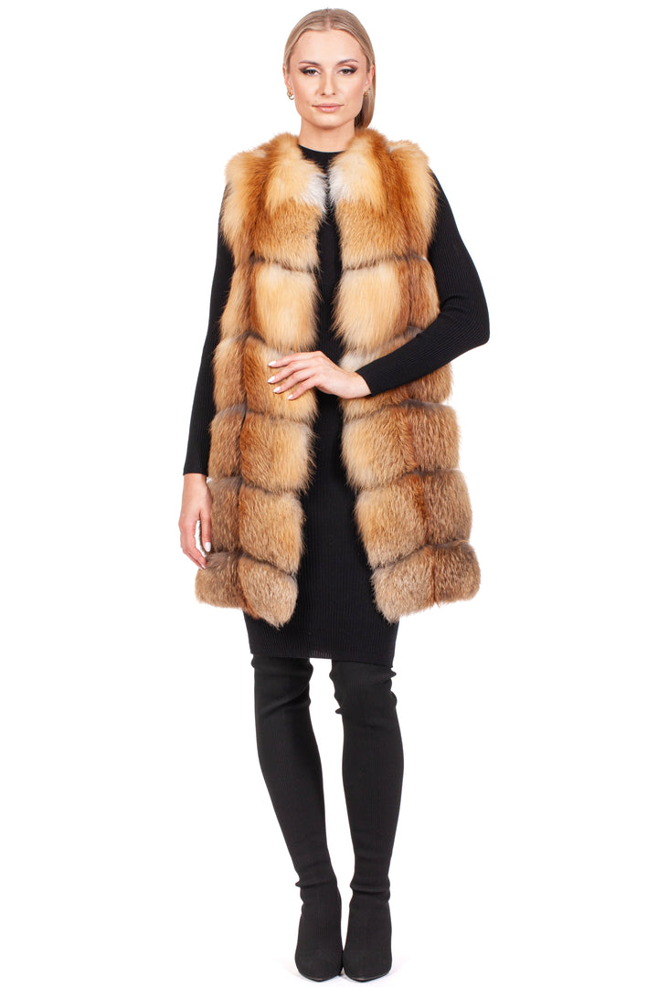 Against a white background, an individual radiates elegance in a long black outfit paired with FurbySD's Long Red Fox Fur Vest. The vest features light brown hues with darker shades, similar to red fox fur, enhancing the sophistication of the ensemble. Their long hair is neatly styled back.