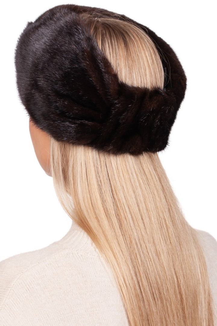 A person with long blonde hair is pictured from behind, adorned with a FurbySD Dark Brown Mink Fur Headband featuring a cashmere lining. They are wearing a light-colored sweater, and the plain white background accentuates the luxurious texture of both the headband and their flowing hair.