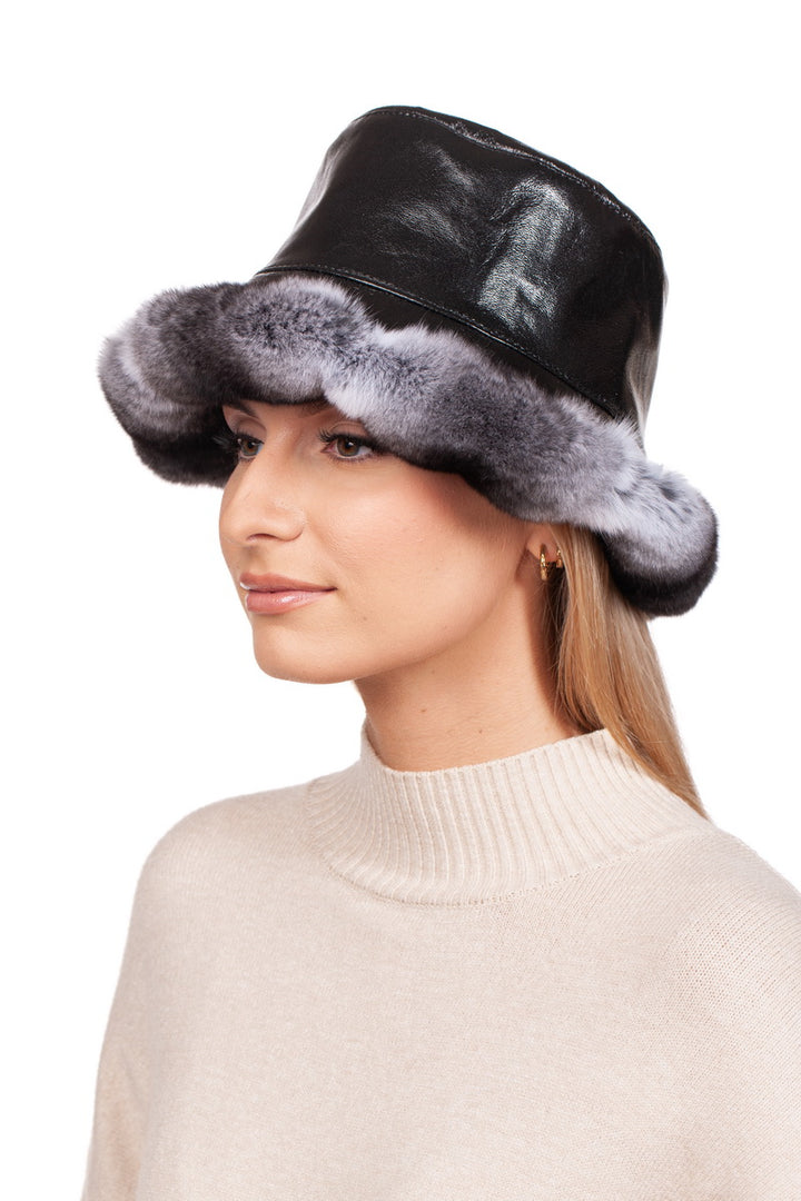 A person in a cream sweater wears an elegant Chinchilla Fur Panama Hat from FurbySD, featuring luxurious gray faux-chinchilla fur trim. They are facing forward and looking to the left against a plain white background.