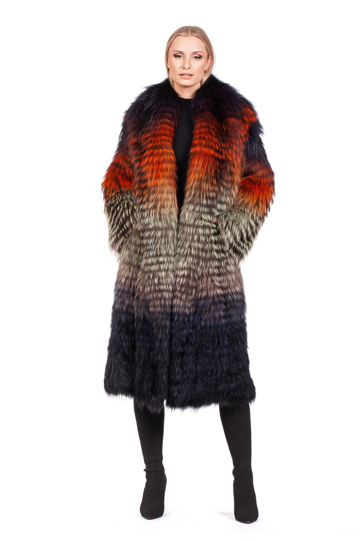 A person is wearing a luxurious Ultralight Fox Fur Coat by FurbySD, showcasing red, orange, and black hues. The coat features a gradient pattern transitioning from vibrant colors at the top to darker shades below. Standing against a white background further accentuates the striking design of the coat.