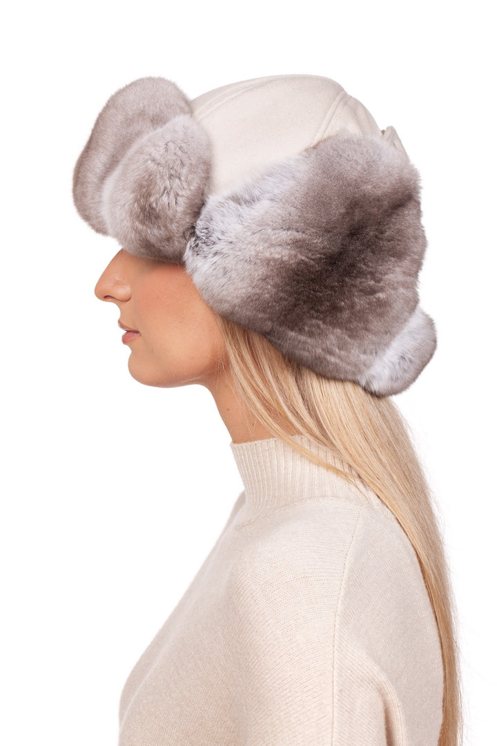 A blond woman wearing chinchilla fur russian earflap hat in beige.