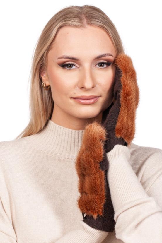 A person with long blonde hair wearing a beige sweater holds one side of their face with a FurbySD Rust Brown Mink Fur Mitten. The plain white background accentuates the mittens' luxurious texture and warmth.