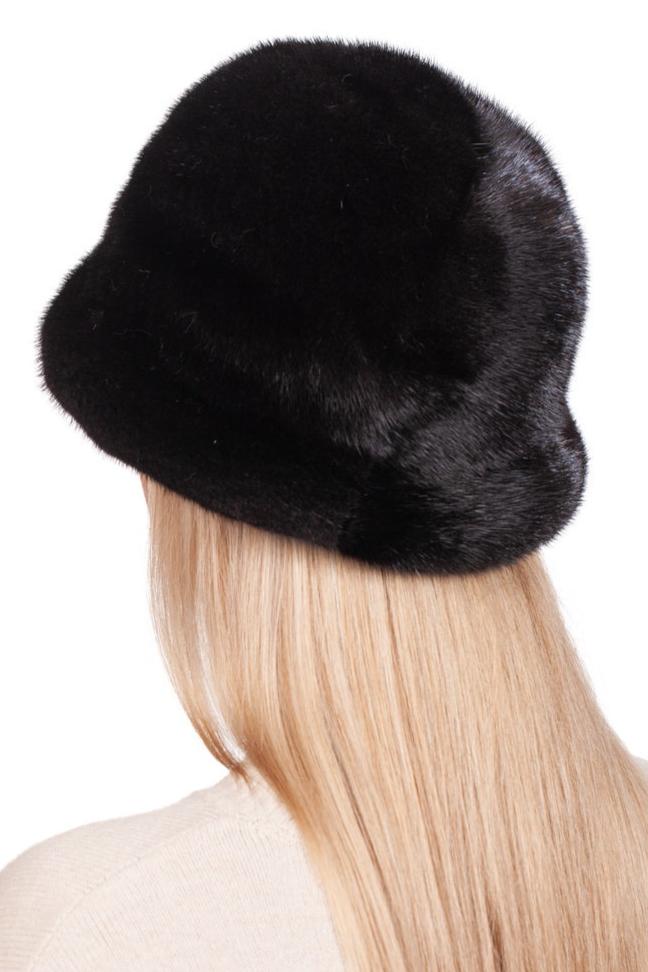 An individual with long blonde hair is wearing a FurbySD Black Mink Fur Bucket Hat along with a cream-colored sweater. They are facing away from the camera, accentuating the luxurious texture of this fashion accessory and the smoothness of their hair.