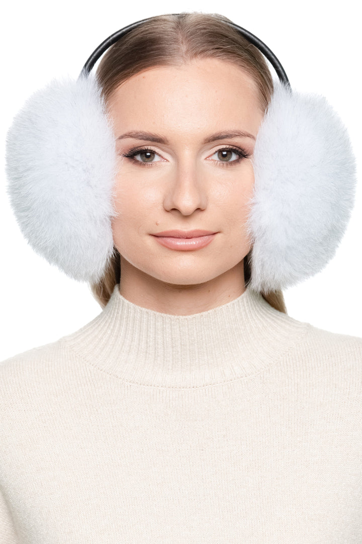 Woman wearing natural blue fox fur earmuffs with leather band – handmade fluffy real fur ear warmers for winter style and warmth.