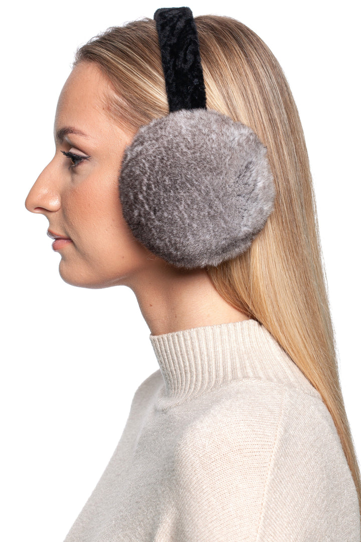 Close-up side profile of a woman wearing genuine grey rex rabbit fur earmuffs with a black astrakhan headband, offering a sophisticated cold-weather accessory.