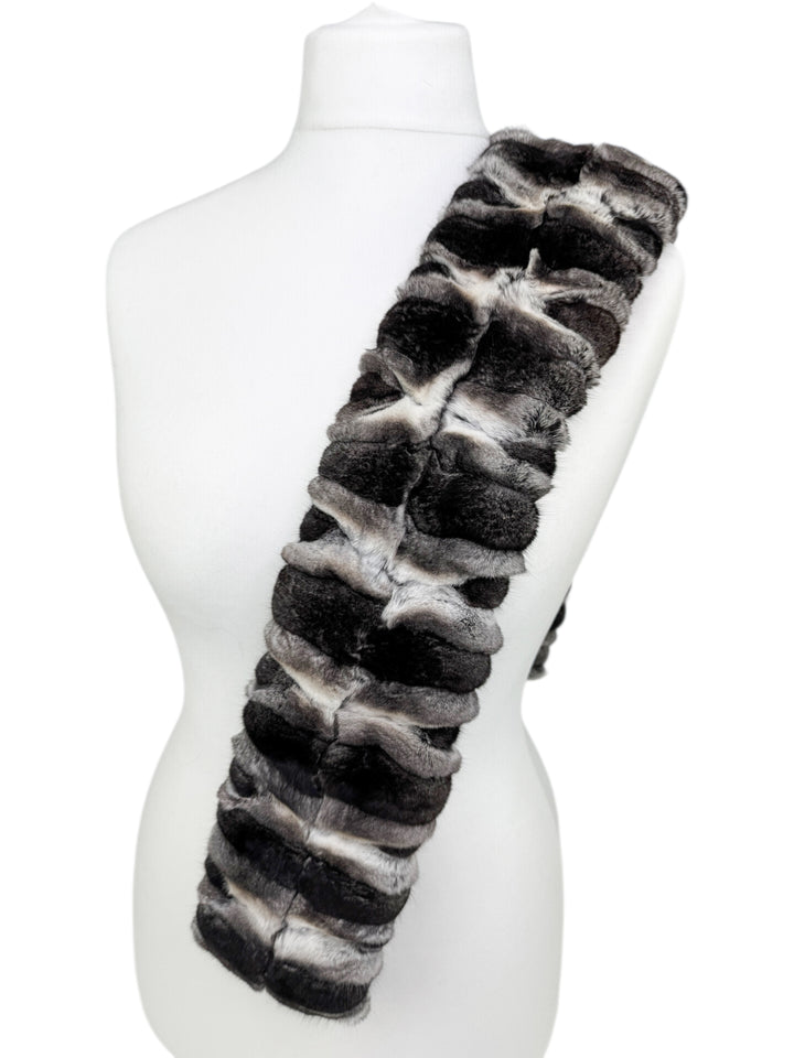 Close-up of genuine chinchilla fur scarf with plush striped texture, unisex winter accessory offering warmth, softness, and timeless elegance.