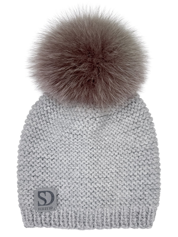 Gray cable knit merino wool beanie with a brown fox fur pom pom on a white background.