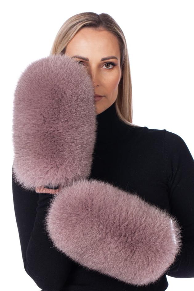 A person wearing a black turtleneck holds up two large, fluffy FurbySD Pink Real Fox Fur Mittens, partially covering their face against a white background.