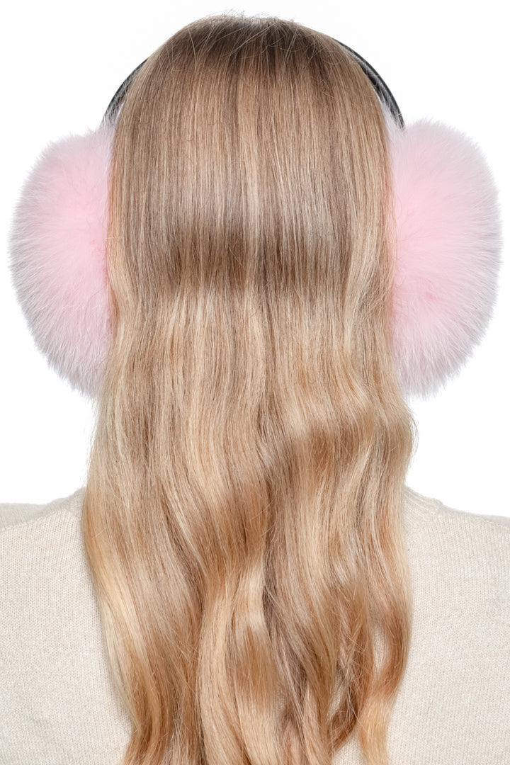 Back view of model wearing handmade pink fox fur earmuffs – luxury fluffy winter ear warmers with real fur.