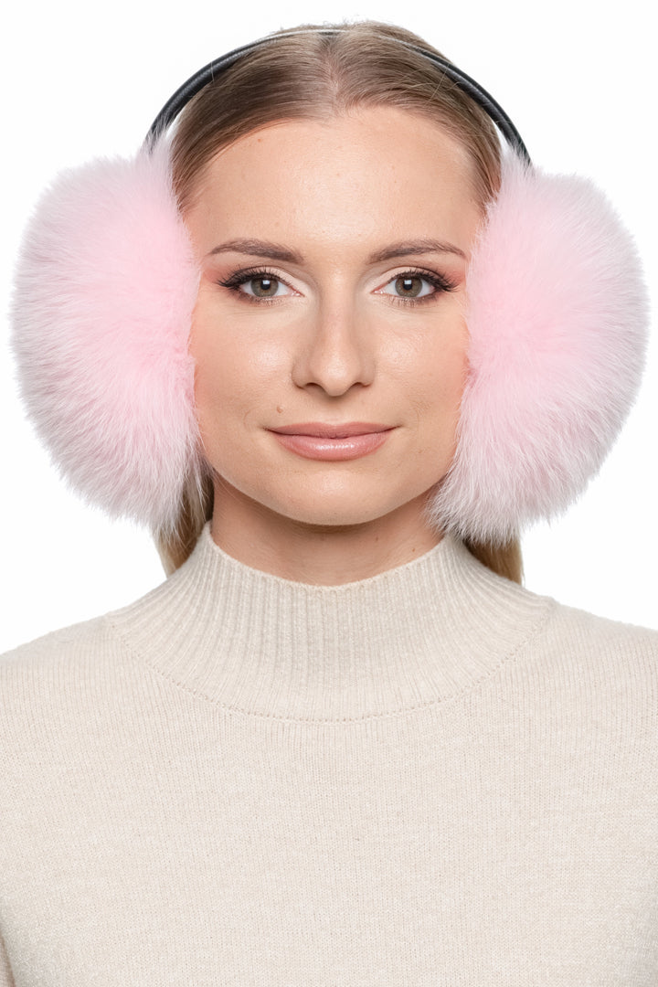 Model wearing large pink fox fur earmuffs with black leather band – luxury handmade fluffy winter ear warmers for women.