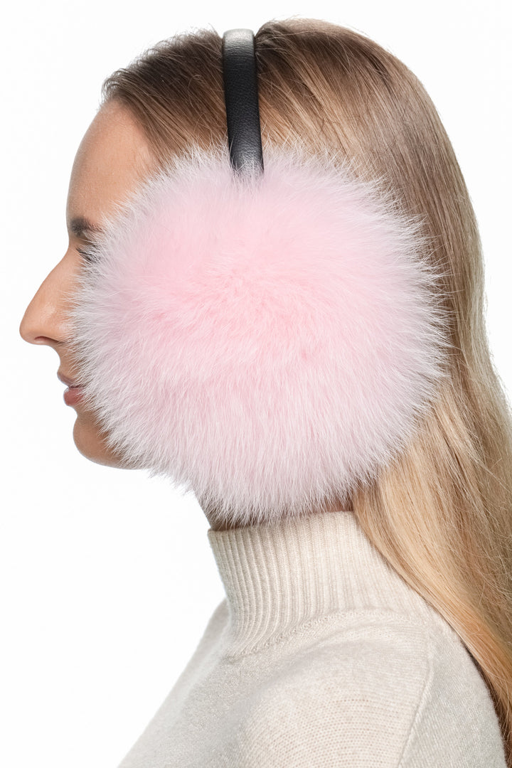 Luxury pink fox fur earmuffs on model side profile – soft fluffy real fur ear warmers for winter.