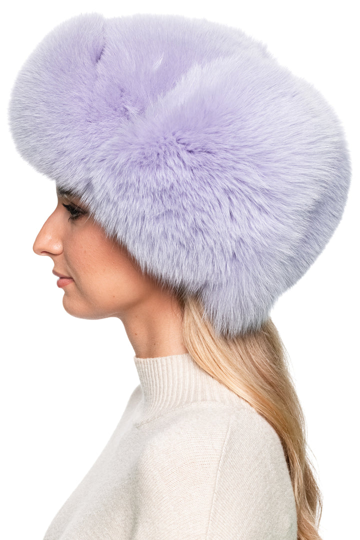 Left side view of purple fox fur aviator hat, oversized fluffy trapper hat with earflaps, handmade luxury winter headwear.