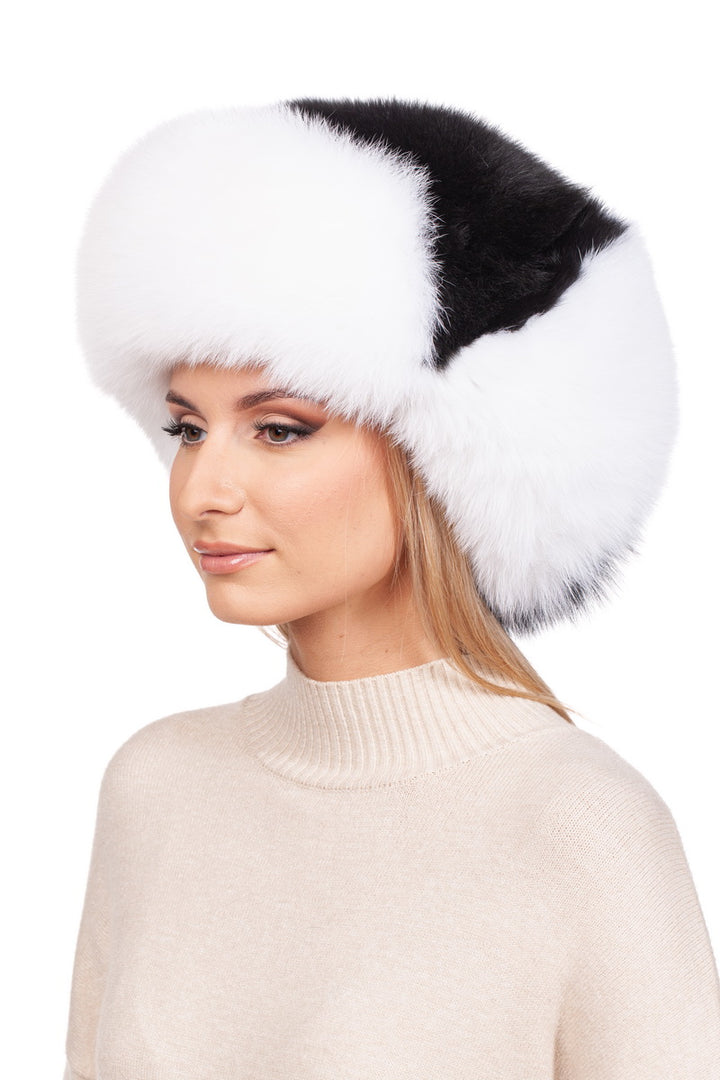 A person wearing the luxurious Fox Fur Ushanka Trapper Hat by FurbySD. They have long hair and are dressed in a cream-colored turtleneck sweater, emanating a quintessential winter style. The backdrop is a plain white setting.