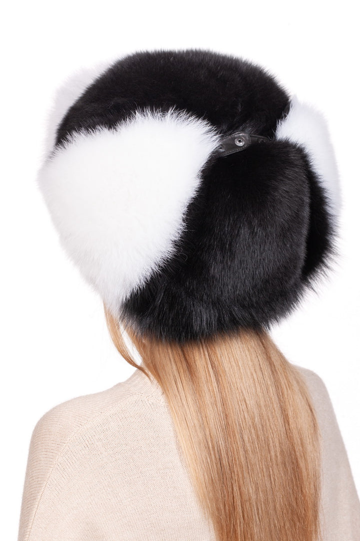 A person with long blonde hair is seen from the back wearing a large Fox Fur Ushanka Trapper Hat by FurbySD. This winter essential features prominent ear flaps and a plush texture, contrasting with the person's light beige sweater.