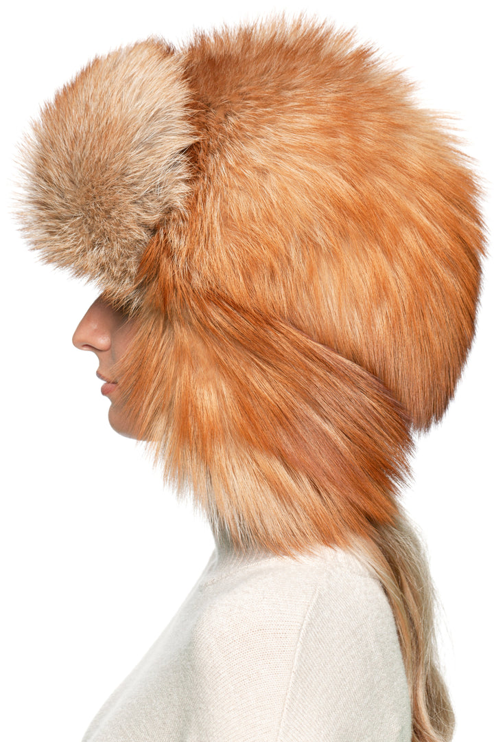 Profile view of genuine red fox fur ushanka hat with chin strap, oversized trapper style hat for men and women in winter.