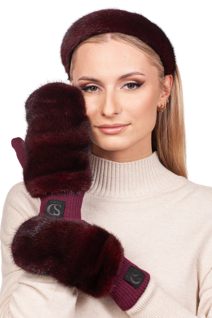 Someone is posing with one mitten-covered hand touching their cheek, wearing a cream-colored turtleneck sweater. They adorn themselves with small hoop earrings and have long, straight hair accessorized by the Red Mink Fur Mittens and Hairband Set from FurbySD.