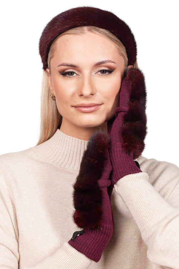 A person dressed in a chic beige sweater and the elegant Red Mink Fur Mittens and Hairband Set from FurbySD strikes a graceful pose. Their long blonde hair enhances the luxurious mink fur headband as they gently touch their face against a plain white background.